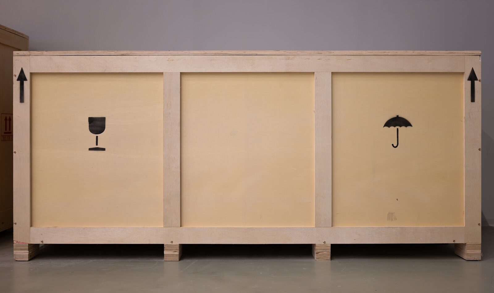 A large wooden crate with shipping symbols